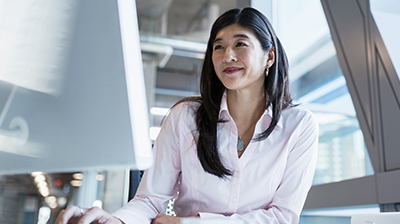 A woman using her computer while sitting at a desk 