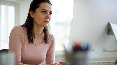 A woman typing on her computer 