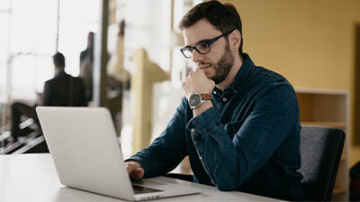 Happy student studying while using laptop.