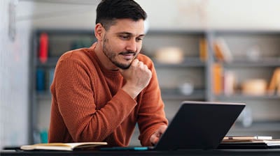 Portrait of a man working on his laptop computer in the coworking space.