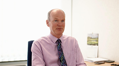 A man sitting in his office responding to a question