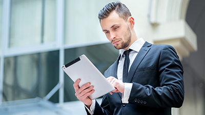 a young businessman reviews work on his tablet