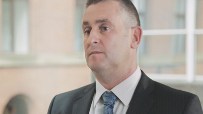 A man in a suit standing in front of the window