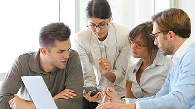 A group of colleagues looking at a smart phone