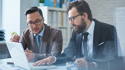 Two business men working together on a laptop